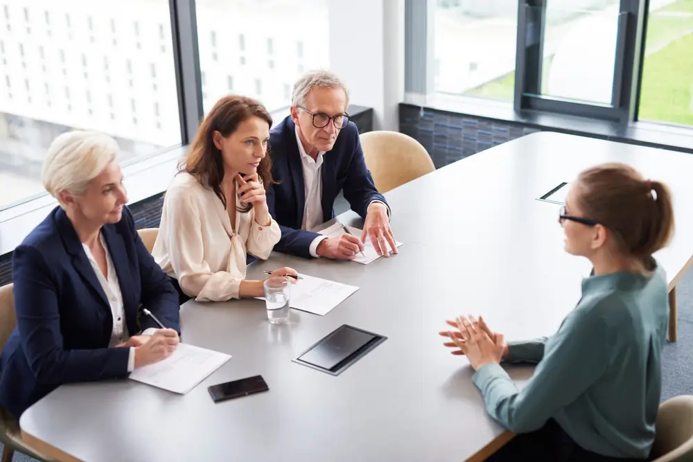 Candidate en entretien de recrutement face à un jury de trois personnes pour devenir sapeur-pompier.