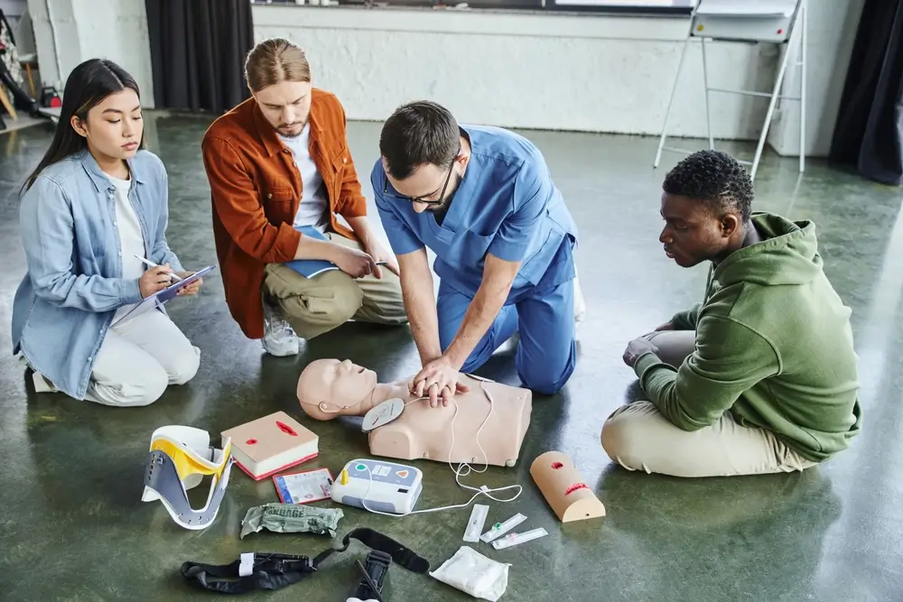 Instructeur démontrant un massage cardiaque sur un mannequin lors d'une formation aux gestes de premiers secours.