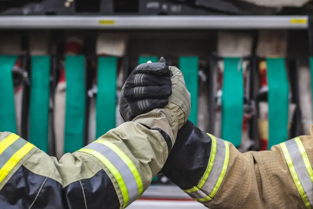Poignée de main entre une recrue et un officier sapeur-pompier en tenue d’intervention marquant l'acte d'engagement.