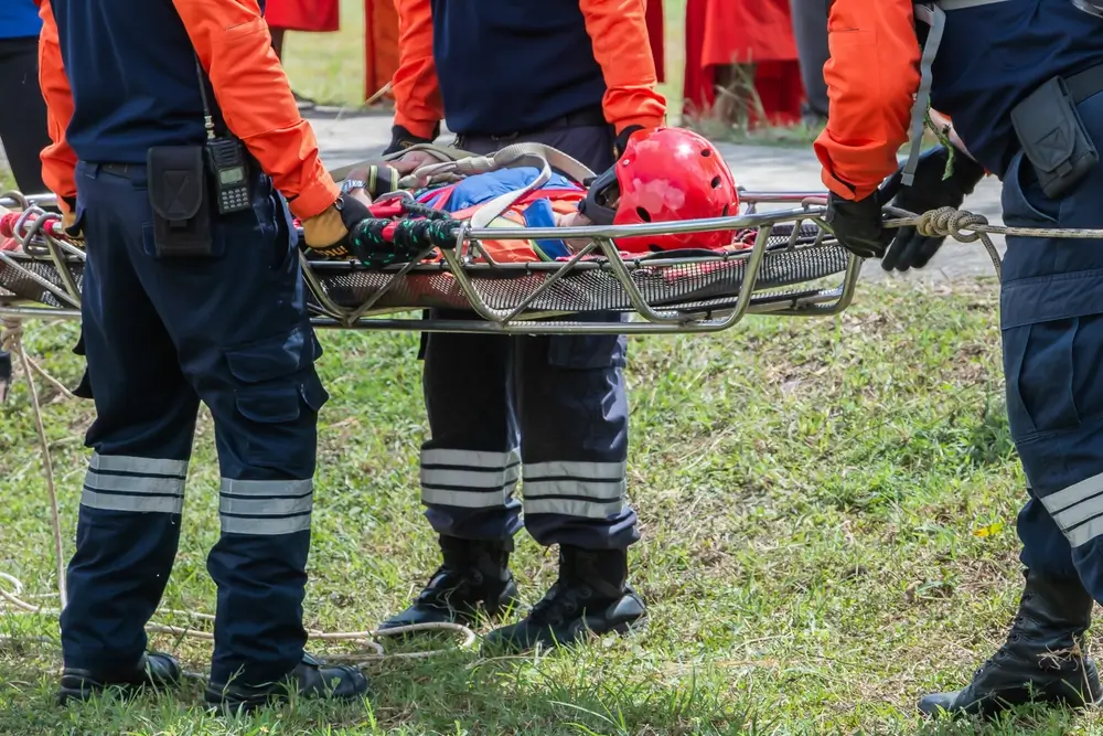 Équipe de secouristes effectuant un exercice de brancardage avec une victime simulée lors d'une formation PSE2.