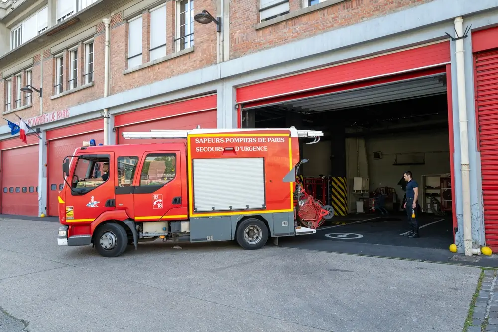 Camion de secours devant une caserne de pompiers, centre d'incendie et de secours prêt pour l'intervention.