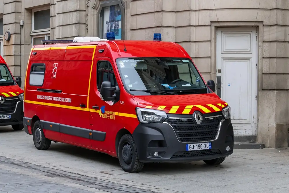 Camions de pompiers stationnés devant une caserne, prêts pour un départ en intervention lors d'une garde.