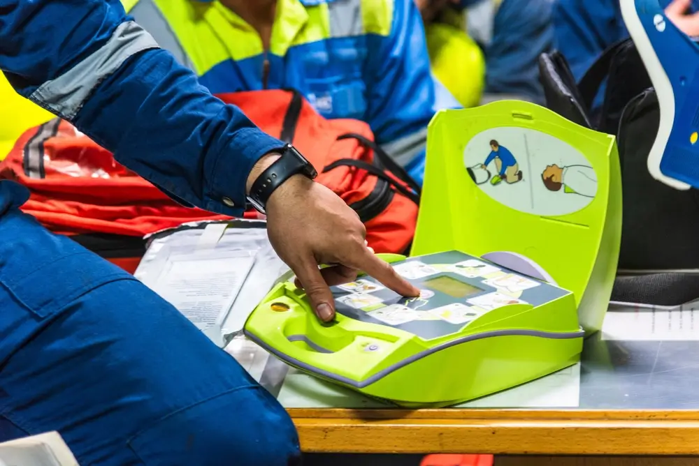 Un participant utilise un défibrillateur automatique externe lors d'une session de formation au secourisme PSC.